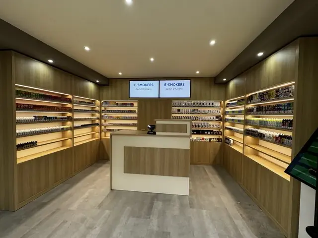 Vista frontale dell’interno del negozio E-smokers Castel d’Azzano con bancone centrale e scaffali illuminati - negozio sigarette elettroniche Castel d’Azzano